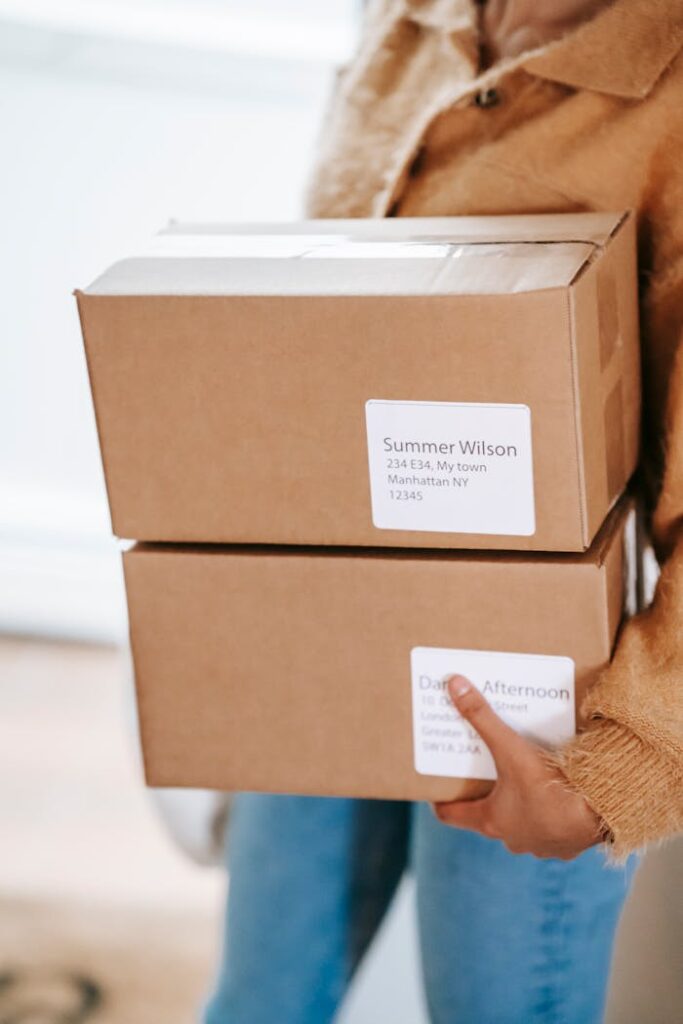 Crop woman carrying boxes in room